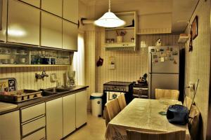 een keuken met een tafel en een koelkast bij Nautical Nook in Aegina Town