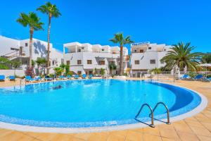 a large swimming pool with palm trees and buildings at Good Mood - Sunny Seaview in Callao Salvaje