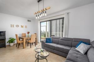 a living room with a gray couch and a table at Full Option 3BR next King David in Jerusalem