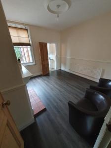an empty living room with a couch and a window at 2 bedroom house - Hopefield Road in Leicester