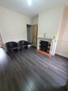a living room with two chairs and a fireplace at 2 bedroom house - Hopefield Road in Leicester