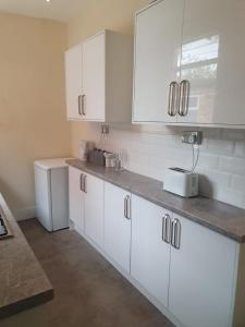 a kitchen with white cabinets and a counter top at 2 bedroom house - Hopefield Road in Leicester