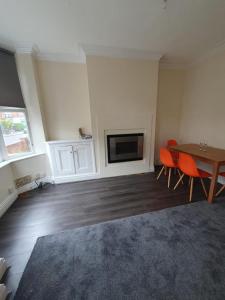 a living room with a table and a fireplace at 2 bedroom house - Hopefield Road in Leicester