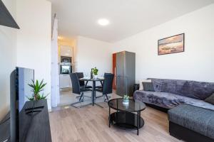 ein Wohnzimmer mit einem Sofa und einem Tisch in der Unterkunft Apartments Sandra in Turanj
