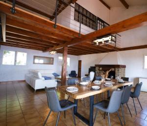 uma sala de estar com uma mesa de madeira e cadeiras em Vue mer 360 La Cataline em Bormes-les-Mimosas