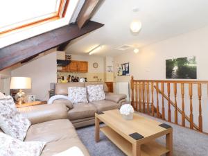 a living room with a couch and a table at Bakers Yard Cottage in Ambleside