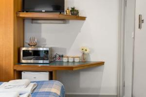 a room with a bed and a microwave on a shelf at The Hidden Gem - Adelaide CBD in Adelaide
