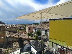 a balcony with a chair and an umbrella at Casa in Centro Storico vista Gran Sasso in Atri