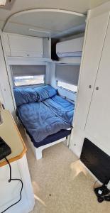 Mały pokój z łóżkiem i biurkiem w obiekcie Przyczepy Jastarnia, 3-4 osobowe na Kempingu SUN4HEL MASZOPERIA w Jastarni