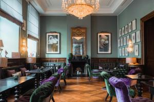 a restaurant with tables and chairs and a chandelier at Althoff Grandhotel Schloss Bensberg in Bergisch Gladbach