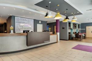 a lobby with a reception counter and a restaurant at Premier Inn Berlin City Centre in Berlin