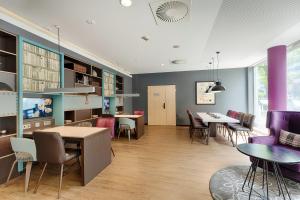 ein Esszimmer mit Tischen, Stühlen und lila Wänden in der Unterkunft Premier Inn Berlin City Centre in Berlin