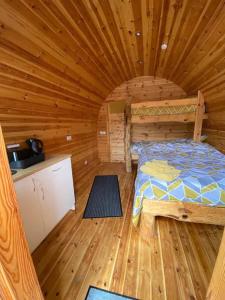 a bedroom with a bed in a wooden cabin at The Plough and Harrow Tilmanstone in Deal