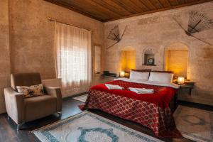 een slaapkamer met een bed en een stoel bij Adelya Cave Hotel Apartments in Goreme