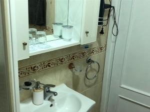 une salle de bain avec un lavabo et un miroir dans l'établissement Apartamento familiar en Toledo, con 2 dormitorios, camas de matrimonio, ideal ubicación y fantàsticas vistas, à Tolède 20 autres photos