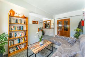 a living room with a couch and a table and bookshelves at Hostal Miramar in Los Caños de Meca