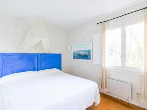 a bedroom with a blue bed and a window at VILLA CANADELL - great garden, 5 min to beach in Palafrugell