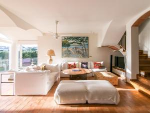 a living room with a white couch and a table at VILLA CANADELL - great garden, 5 min to beach in Palafrugell