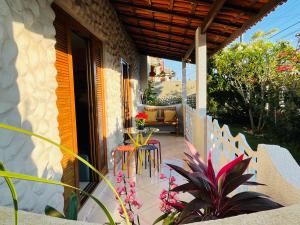 a patio with a table and chairs on a house at Casa Cheia de Alegria e Sol in Peruíbe