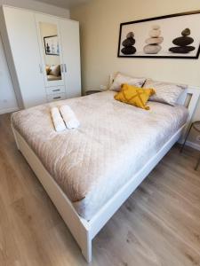 a bedroom with a bed with two towels on it at Vasaros estrados apartamentai, self check-in, free parking in Klaipėda