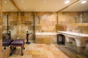ein großes Badezimmer mit einem Waschbecken, einer Badewanne und einem Waschbecken in der Unterkunft Hotel U Prince Prague by BHG in Prag