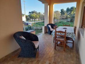 ein Esszimmer mit einem Tisch und Stühlen auf einer Veranda in der Unterkunft Villa Delia 600mt dal mare IUN R2818 in Capo Comino