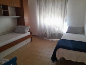 Zimmer mit 2 Betten und einem Fenster in der Unterkunft Villa Delia 600mt dal mare IUN R2818 in Capo Comino
