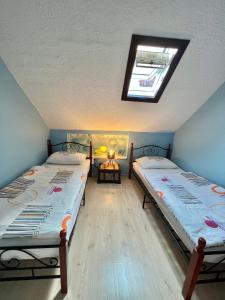 two twin beds in a room with a skylight at Apartment Nikolina in Trogir