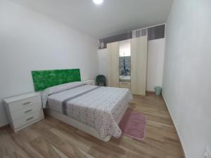 a white bedroom with a bed and a mirror at Bazan Apartaments2 in Alicante