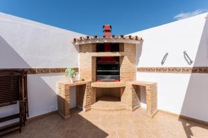 - un four en briques dans un patio avec toit dans l'établissement MalagaSuite Skyviews Fuengirola, à Fuengirola