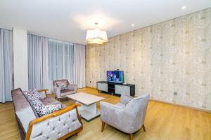 Una sala de estar con dos sillas y un televisor. en Baku İn Front of hotel apartment, en Baku