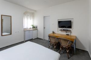 埃拉特Little Prince Hostel-5 Min Walk To The Beach的一间卧室配有书桌、一张床和一台电视。