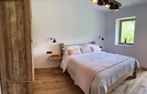 Un dormitorio con una cama con almohadas rosas y una ventana en The Vila Bled Premium Luxury Retreat, en Bled