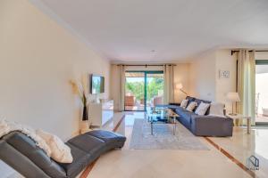 a living room with a couch and a table at Modern and Spacious 2 BDRM Penthouse - 3 Pools and Sea Views in Marbella