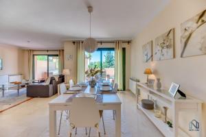 a dining room and living room with a table and chairs at Modern and Spacious 2 BDRM Penthouse - 3 Pools and Sea Views in Marbella