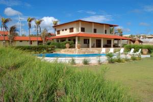 a house with a swimming pool in front of it at Aqua Villa by Garvetur in Beberibe