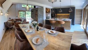 un comedor con una larga mesa de madera y sillas en The Vila Bled Premium Luxury Retreat en Bled