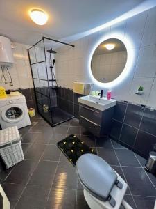 a bathroom with a toilet and a sink and a washing machine at Apartment Nikolina in Trogir