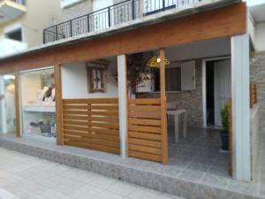 a store front with a wooden door and a balcony at Natasas Apartments in Alykes