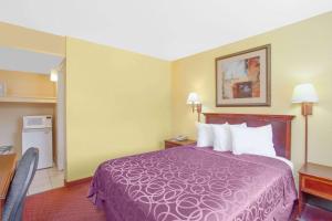 Una habitación de hotel con una cama morada y una cocina. en Baymont by Wyndham Coalinga, en Coalinga 26 fotos más