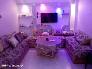 un soggiorno con divano e tavolo di Appartement near airport ouled tayeb a Al Hachlaf