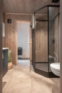 a bathroom with a glass shower and a sink at Luxury Nordic Suite with Private Sauna and Panoramic Mountain Views in Stranda