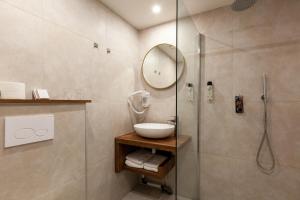 a bathroom with a shower and a sink and a mirror at Amsterdam Hotel Uithoorn in Uithoorn