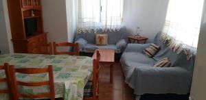 a living room with two couches and a table at Casa El Algarrobico in Agua Amarga