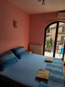 a bedroom with a large bed with two towels on it at Apartman Aleksa in Bela Crkva