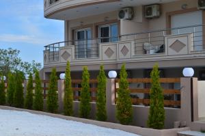 a building with a fence and trees in front of it at Thassos Grand Villas Apartments & Studios in Limenaria