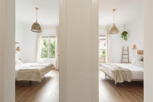 バルセロナにあるKeyFamily Sweet Homeの白い壁のベッドルーム1室(ベッド2台付)