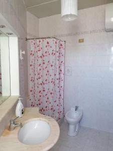 a bathroom with a sink and a toilet and a shower curtain at Appartamento I Mulini in Trapani