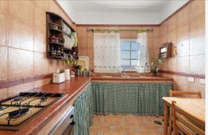 Casa María - Finca Medina في Alojera: مطبخ مع مغسلة وموقد فرن علوي