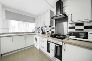 a kitchen with white cabinets and a stove top oven at ✪ 2-Bed Ground Floor Flat ✪Chelmsford✪ Prime Location in Chelmsford